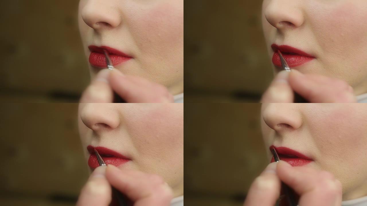 化妆工作室涂红色唇膏的过程。美丽的女性