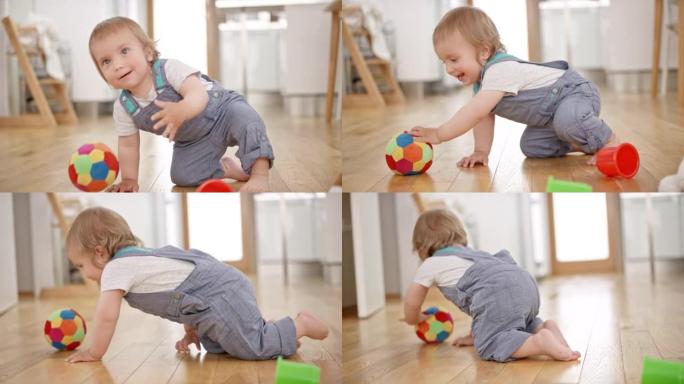 SLO MO男婴玩一个柔软的球，并在绑球时摔倒以抓住它
