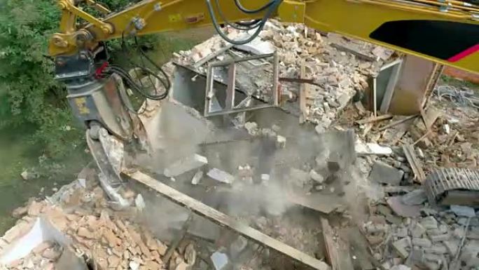 空中挖掘机拆除了被拆除的旧建筑物的最后一块