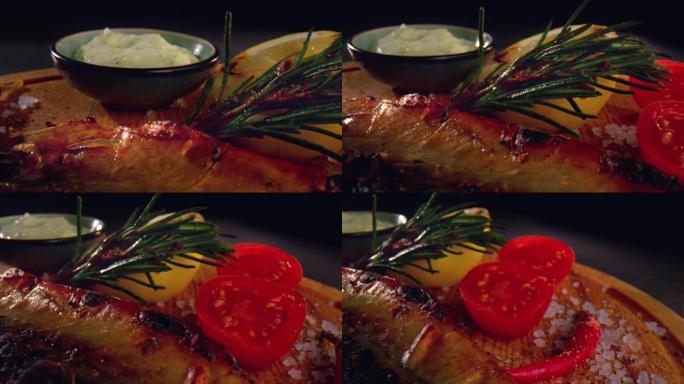 在木盘上烤鲭鱼，切成薄片的西红柿，柠檬，苏，红辣椒