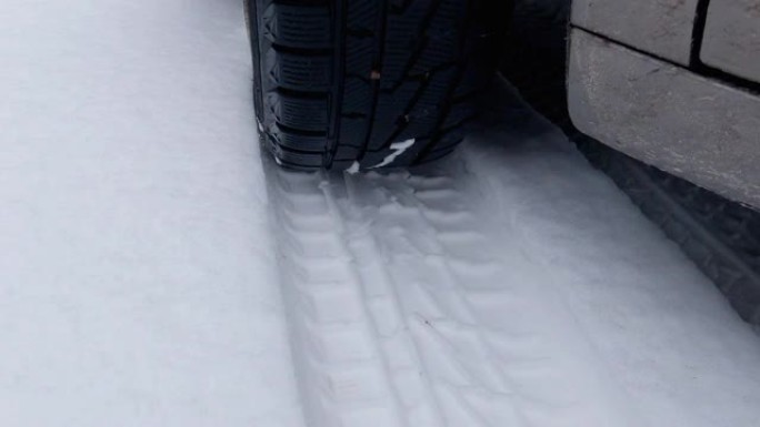 雪地上的汽车车轮和轮胎痕迹的一部分