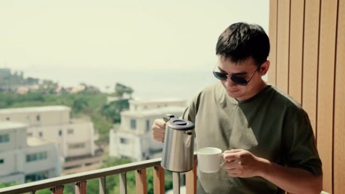 年轻人戴着墨镜，在阳台上玩智能手机和喝咖啡。