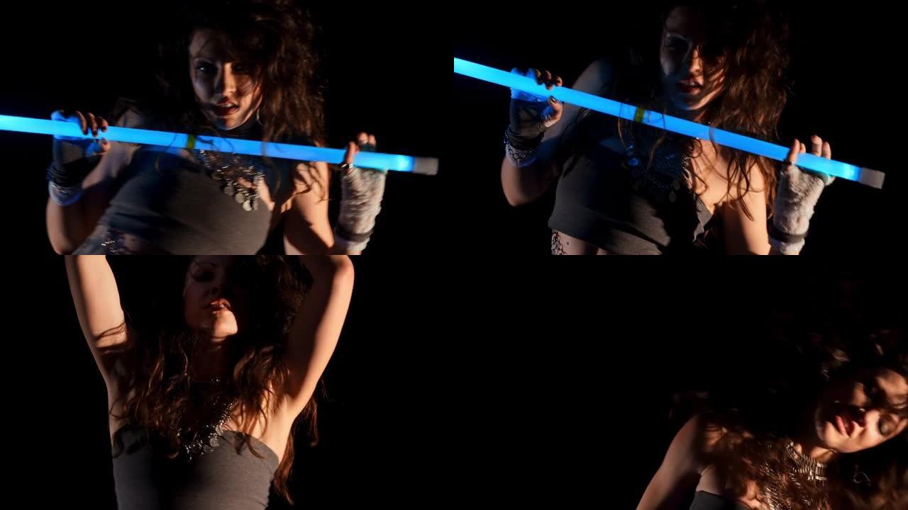 吉普赛女子在霓虹灯中与紫外线杖跳舞抽象表演