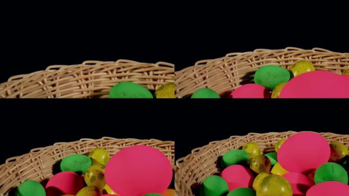 柳条篮中的彩色绿色、粉色、黄色复活节彩蛋 -- 黑色背景 & 特写