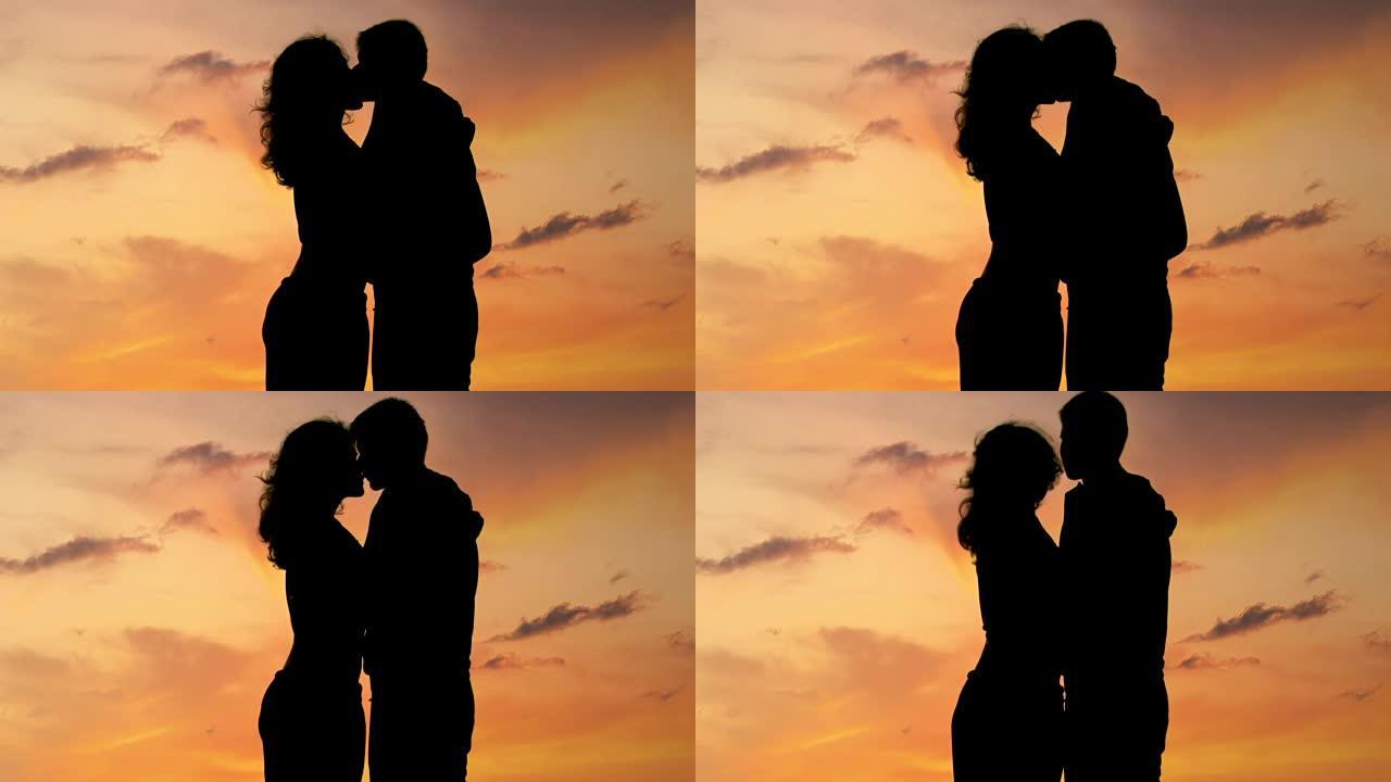 美丽浪漫的情侣享受迷人的日落，亲吻和拥抱，特写