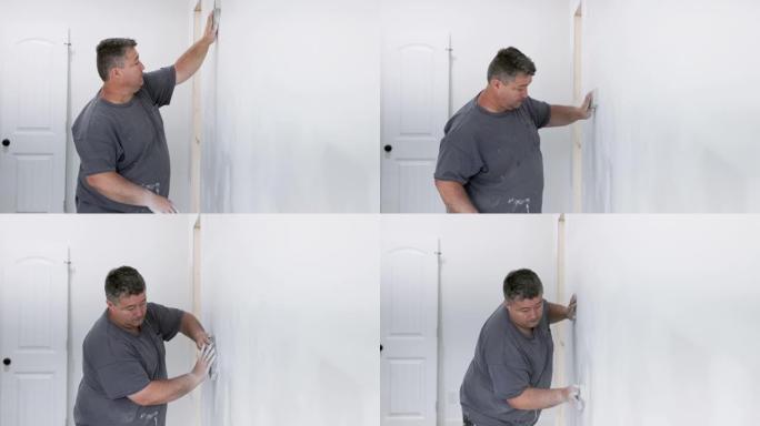 高加索杂工在新房子里打磨墙壁。慢动作视频。