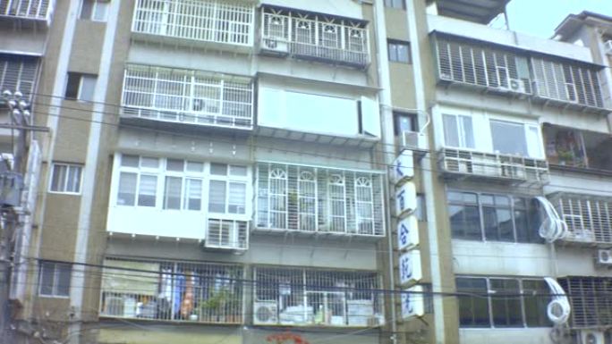 台湾台北-2019年1月28日: 犹太人区旧肮脏亚洲公寓楼的水平视图，带有中国诊所和百合干洗的广告广