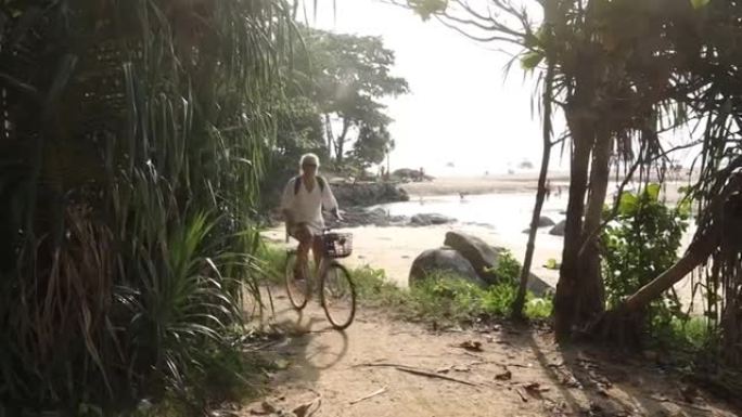 女人沿着海滩小径骑自行车