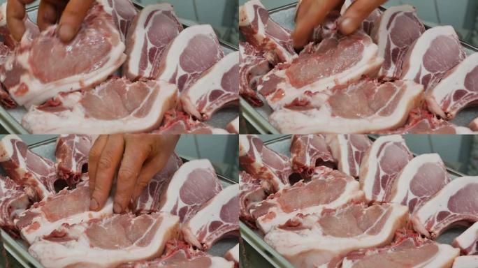 肉店里卖肉者的特写镜头，将生肉猪肉放在有机农村产品零售的陈列柜上。