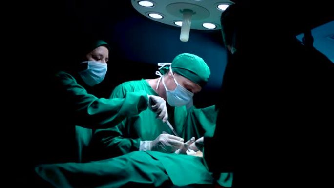 4k，两名护士是进行手术的医生助手，正在帮助吸收躺在床上等待医生进行手术的血液患者，为患者保持清洁和