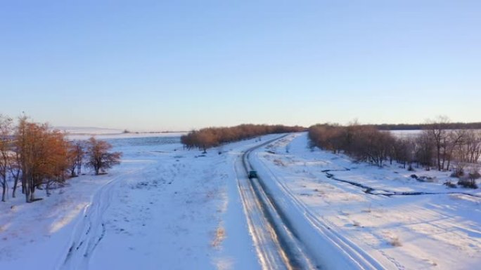 黑车在雪中行驶在城外公路，后视