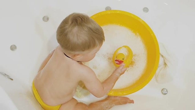 可爱的小男孩在浴缸里玩橡皮鸭