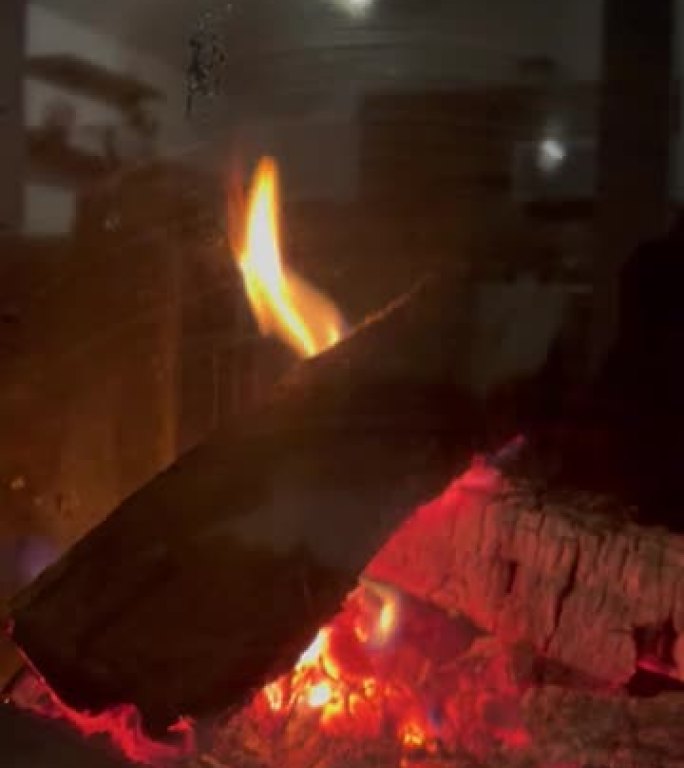 家庭壁炉特写。垂直装饰篝火视频。封闭烟囱内燃烧明亮的火焰，镜面反射