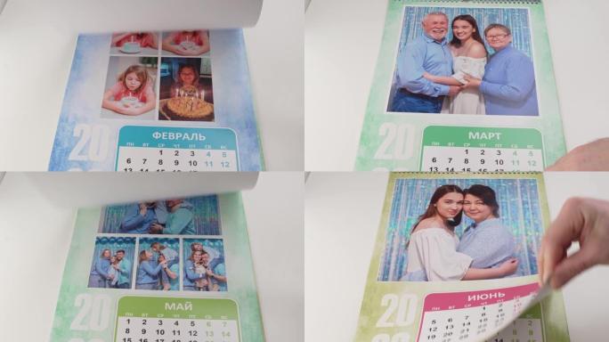 一只手翻转带有家庭照片的翻转日历。