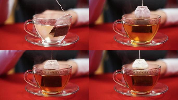 下午茶时间，女性泡红茶，把茶袋放在杯子里。