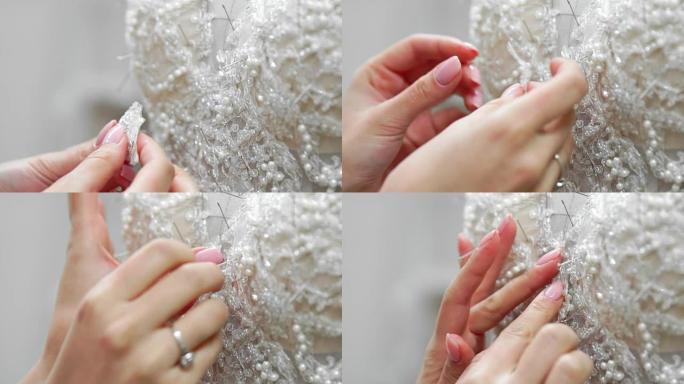 在他的工作室为新娘准备的特写时装设计师pinse needles蕾丝婚纱。女裁缝打造专属婚纱。用针脚