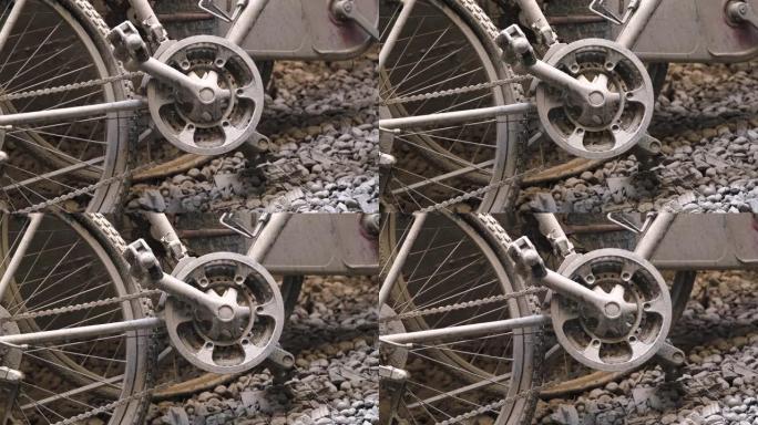废弃的自行车踏板，左倾在沙壁上，在瓦砾覆盖的地面上，被泥土覆盖