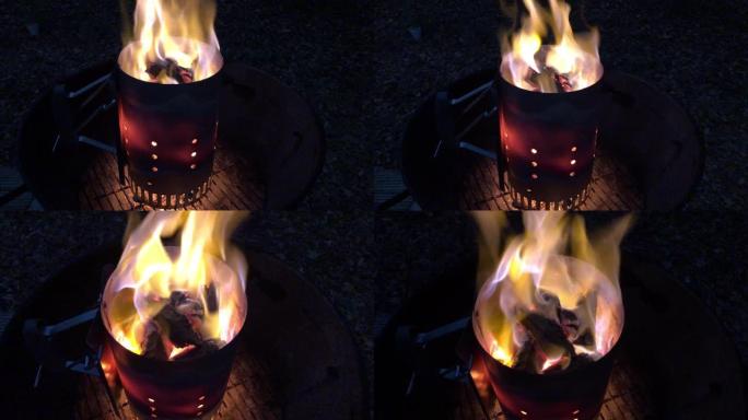 在烟囱启动器中燃烧木炭的烤架准备工作，随着热而泛红，从侧面到上方的视图