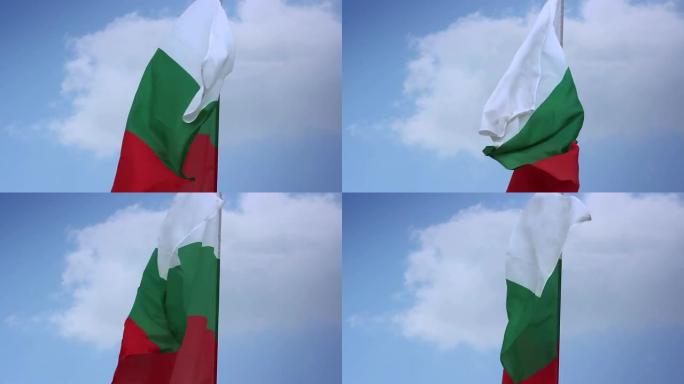 蓝天中，旗杆上飘扬着保加利亚国旗。保加利亚