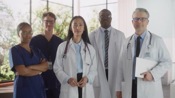 一名男女成功的多元化医疗保健专业人员的团队肖像，他们作为一个团体站在现代医院办公室里，摆姿势，看着相