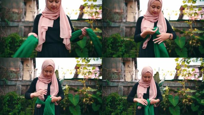 一群穆斯林妇女在花园里练习舞蹈前，在腰间系上一块有图案的布