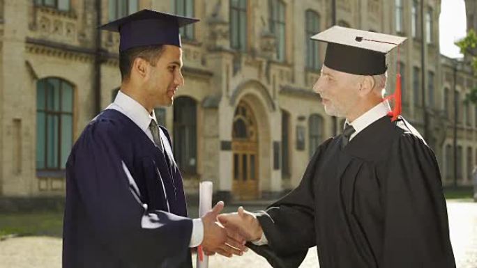 大学校长为男生握手毕业日颁发文凭