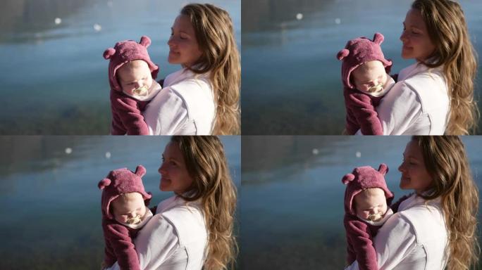 一个年轻的母亲和婴儿在高山湖岸观光的特写镜头