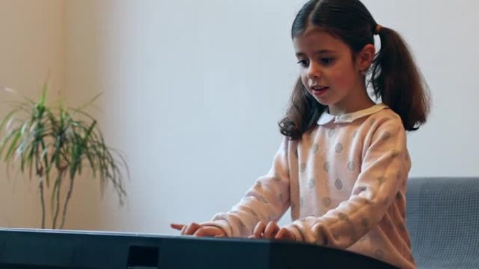 一个小女孩弹电钢琴。
