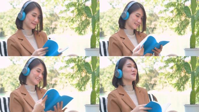 快乐的亚洲女人使用耳机在绿色公园大自然的户外听智能手机的音乐。放松女人的音乐心理治疗师。休闲开朗的健
