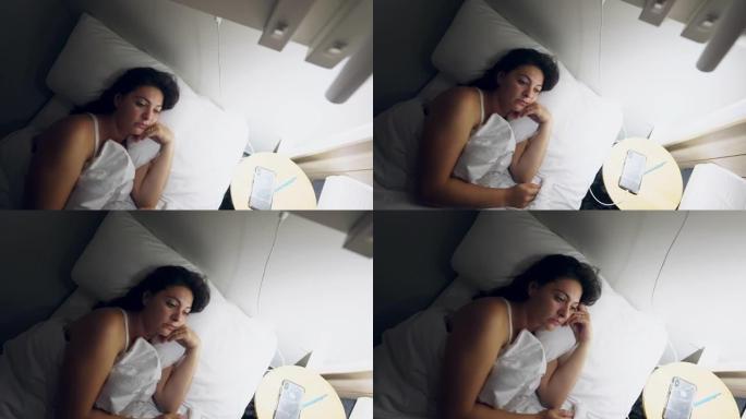 女人晚上躺在床上睡不着。半夜失眠的人在沉思中感到压力