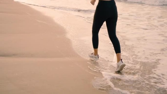 健康的生活方式女人早上在海滩上锻炼和跑步。