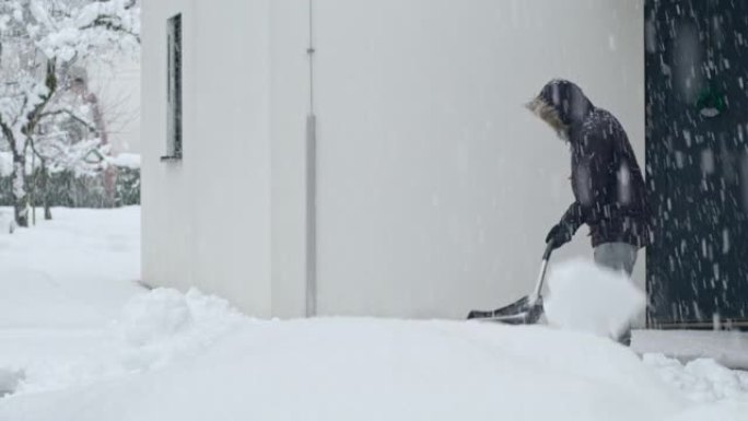 LD男子在大雪中在屋前铲雪
