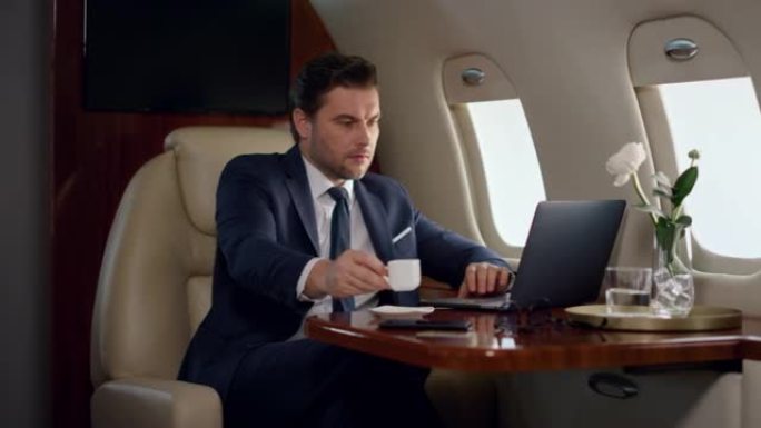 飞机上压力专业工作笔记本电脑。专注的人喝咖啡