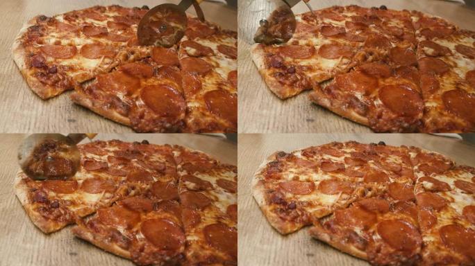 男人用圆刀在厨房的木桌上手工切披萨。美味的意大利辣香肠的特写镜头被切成碎片。