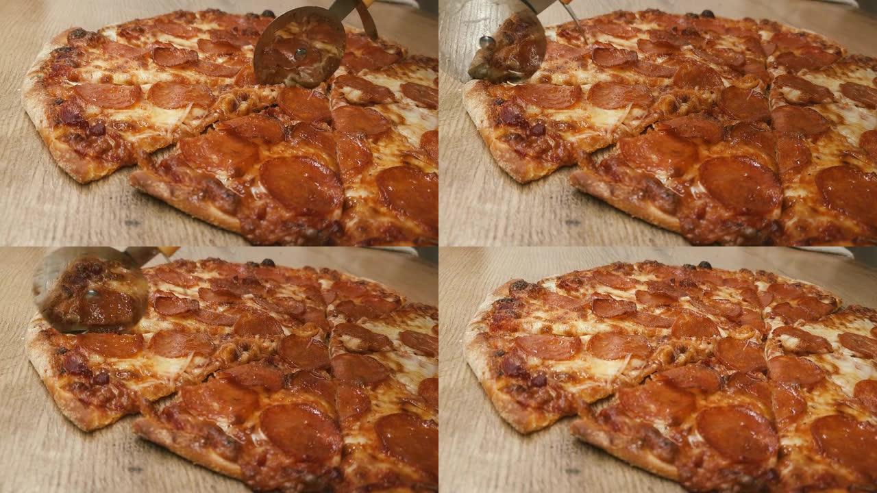 男人用圆刀在厨房的木桌上手工切披萨。美味的意大利辣香肠的特写镜头被切成碎片。