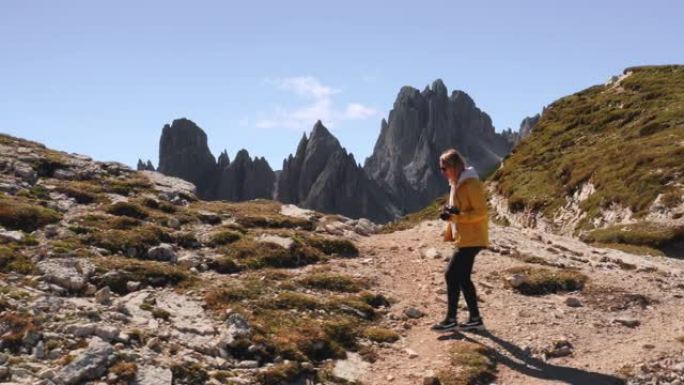 好奇的女人走上巨型山丘，探索意大利阿尔卑斯山