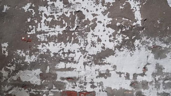 灰色旧裂缝墙为背景。工业建筑中带有裂缝的垃圾混凝土水泥墙