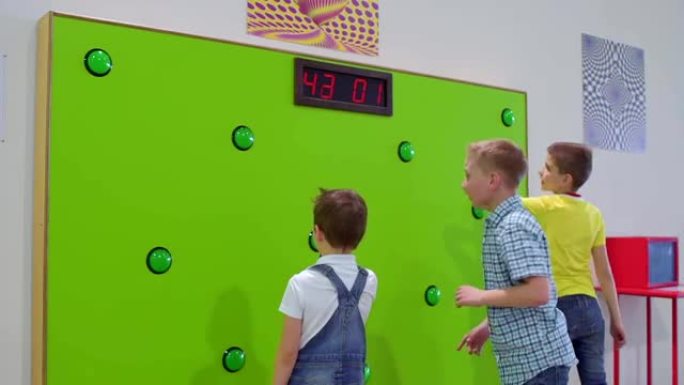 三个男孩在科学博物馆玩反应速度的游戏