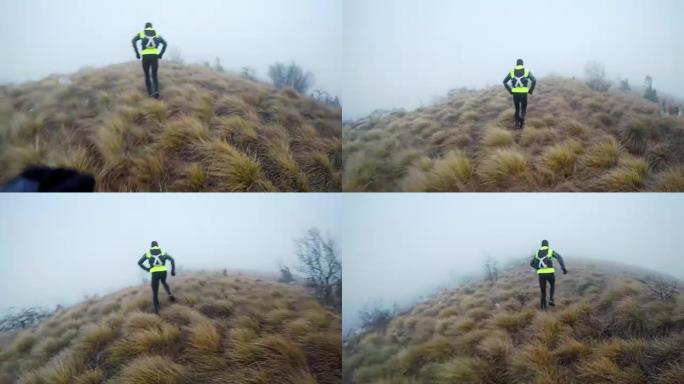 在一个寒冷的早晨，POV跑步者在他的油炸食品后面跑过雾蒙蒙的山