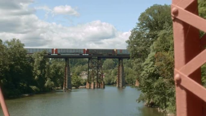货运火车越过风景秀丽的山桥越过河。