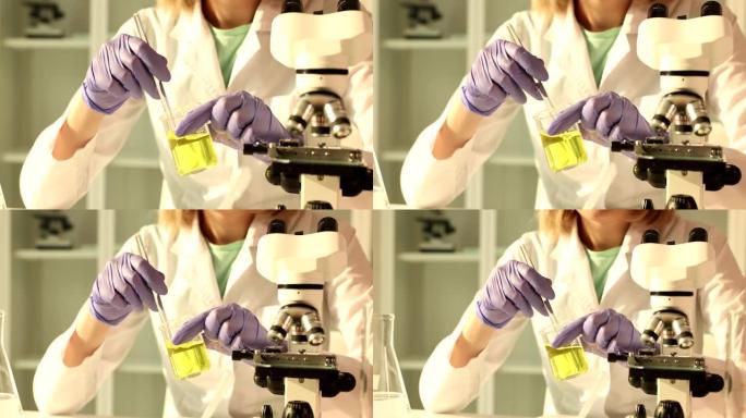 化学科学家在化学实验室中拿着黄色液体的酒瓶并搅动