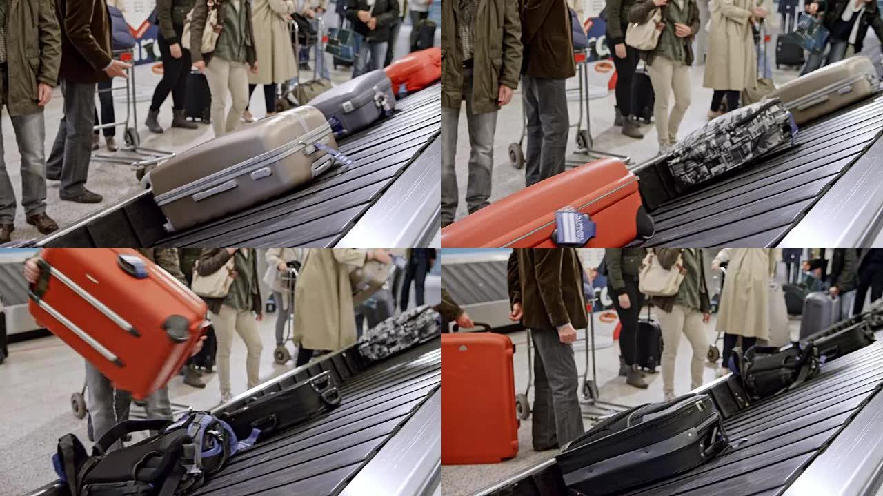 LD高级男子在机场将旅行包从行李传送带上拿下来