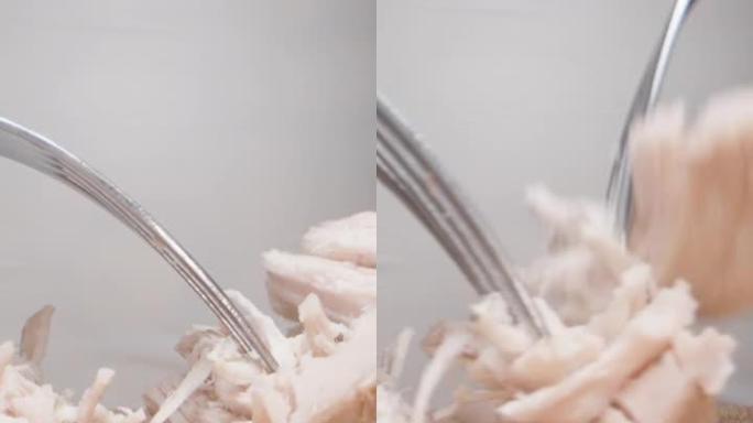 厨师用叉子撕下煮熟的鸡片，非常特写。滑动垂直视频社交媒体