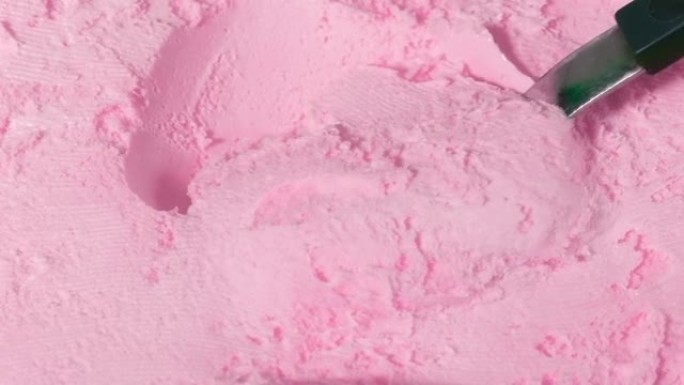 人用勺子舀草莓口味冰淇淋