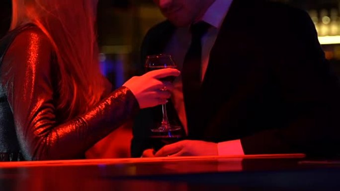 年轻女子在夜总会与男人调情，情侣享受葡萄酒约会