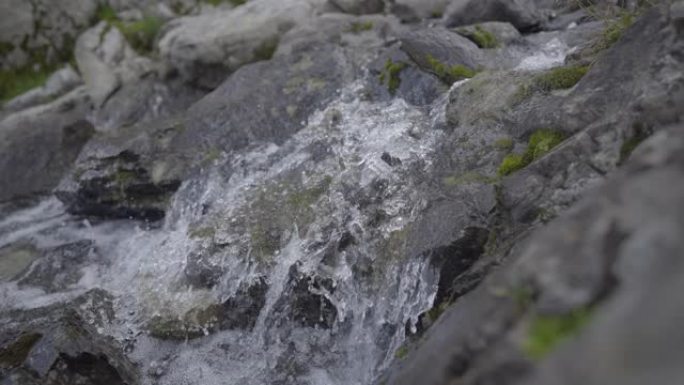 在岩石山坡上流水的详细镜头