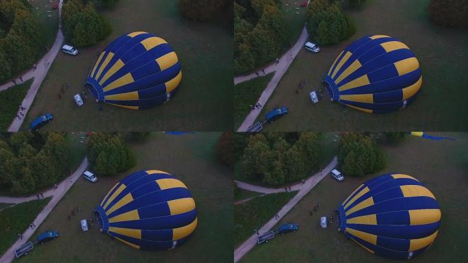 人们在地面上膨胀热气球信封，准备飞行
