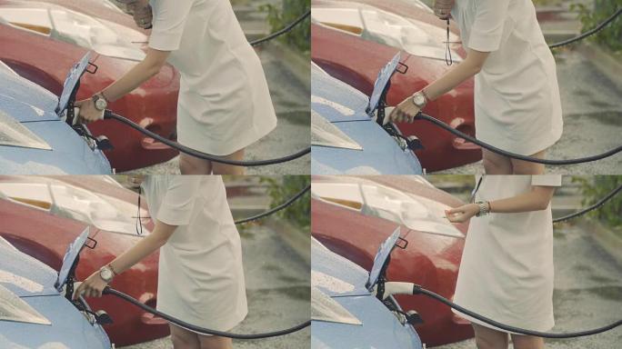 女人在下雨时给电动汽车充电