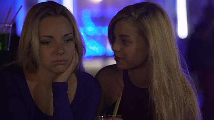 年轻女子在聚会上支持沮丧的女性朋友，分手后抑郁