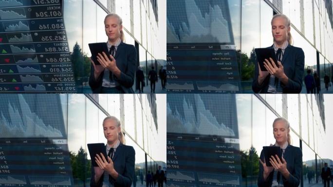 TS年轻的女性专业人士在她的数字平板电脑上使用交易应用程序，同时沿着现代商业大楼行走